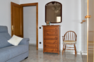 Bedroom 3 with wall wardrobe, sofa and door to the large patio